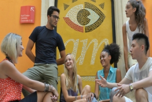 マルタの人気語学学校AM Language Studioのロゴ前で談笑する生徒達