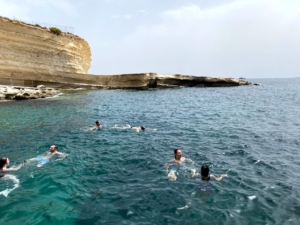 6月のマルタの海で泳ぐ人たち